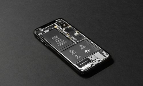 Imagen de alta resolución de un teléfono inteligente que muestra sus componentes internos sobre una superficie oscura.
